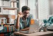 Man wearing glasses doing research on his laptop