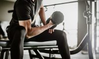 Man working out with a dumbbell in a gym